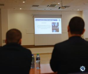 Dwaj mężczyźni patrzą na prezentację wyświetlaną na ekranie.