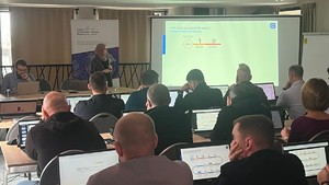Uczestnicy konferencji siedzą za stołami.