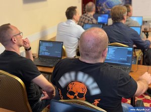 Uczestnicy konferencji siedzą za stołami.