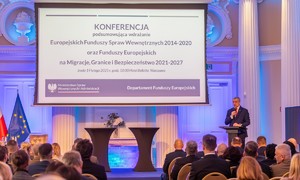 Uczestnicy konferencji siedzą za stołami.