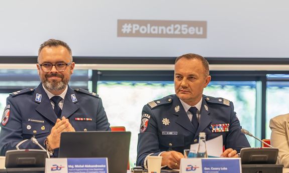 Dwóch policjantów siedzi przy dużym stole.