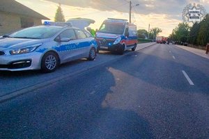 Miejsce wypadku drogowego. Na drodze stoi radiowóz i karetka pogotowia.