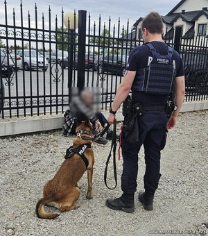 policjant z psem policyjnym stoją obok zaginionego.