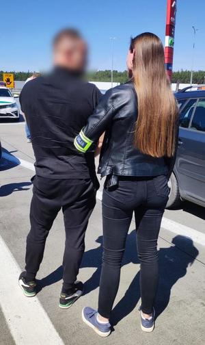 Funkcjonariuszka z zatrzymanym w kajdankach.
