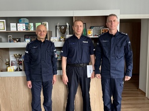 Trzej umundurowani policjanci pozują do zdjęcia.