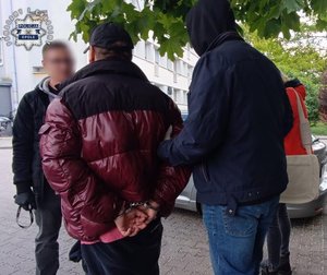 Dwaj funkcjonariusze z zatrzymanym.