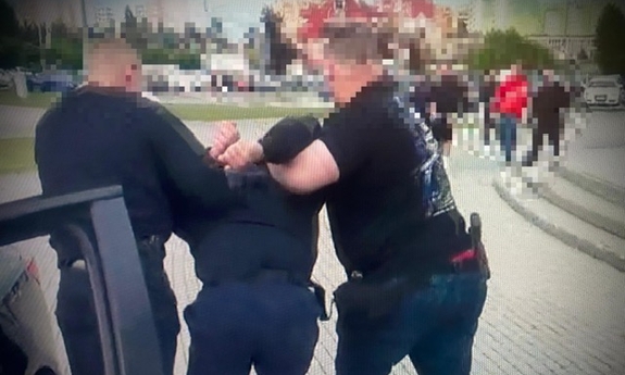 Policjanci prowadzą zatrzymanego.