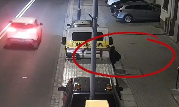 kadr z monitoringu, mężczyzna próbuje włamać się do samochodu i ucieka widząc policję.