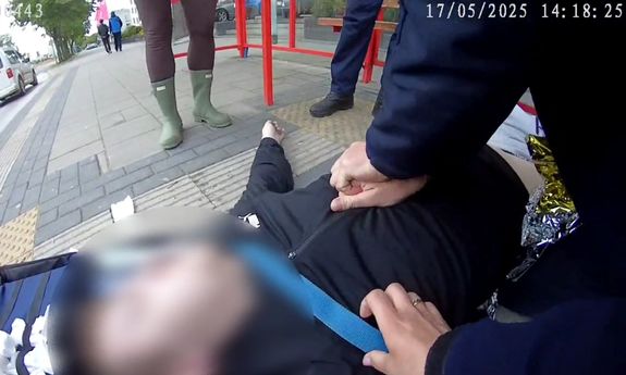 Policjant uciska klatkę piersiową nieprzytomnego mężczyzny - stop klatka z filmu.