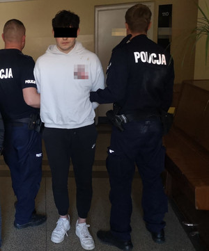 zatrzymany stoi z policjantami.