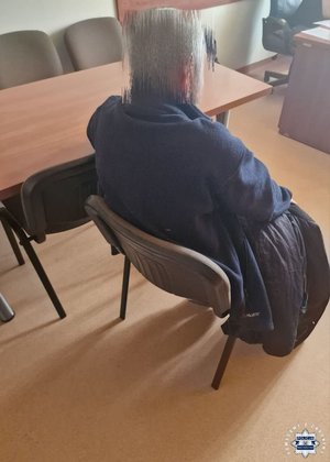 Zatrzymany mężczyzna siedzi na krześle.