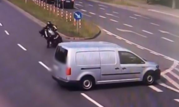 kadr z monitoringu. motocyklista kładzie motocykl żeby złagodzić uderzenie.