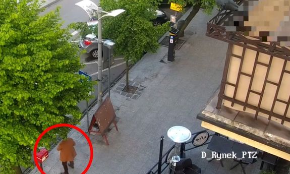 Zrzut obrazu z monitoringu. Mężczyzna stojący na ulicy. Jego sylwetka znajduje się w czerwonym kółku.