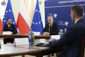 Uczestnicy odprawy służb siedzą przy stole obrad.