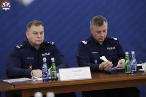 Uczestnicy odprawy służb siedzą przy stole obrad.