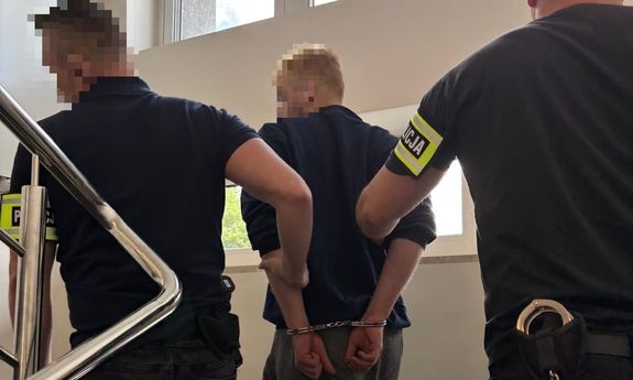 dwóch policjantów idzie z zatrzymanym.