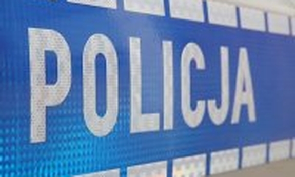 Napis Policja na drzwiach radiowozu policyjnego.
