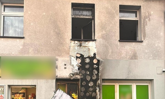 Zniszczona pożarem elewacja budynku.