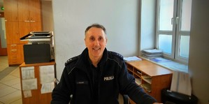 policjant siedzi przy biurku.