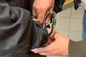 Zakładanie kajdanek zatrzymanej osobie.