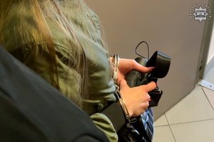 Ręce zatrzymanej kobiety w kajdankach.
