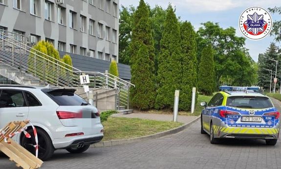 Radiowóz eskortuje samochód osobowy do szpitala.