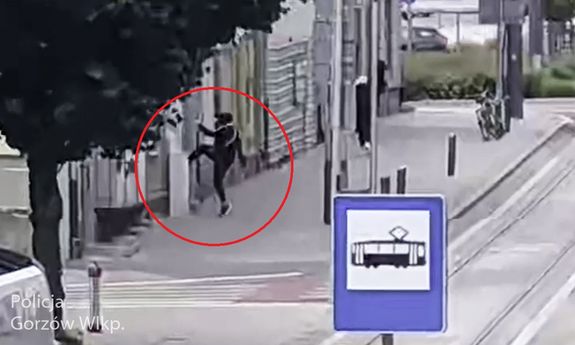 Stop klatka z nagrania z monitoringu, na którym mężczyzna kopie w szybę sklepową.