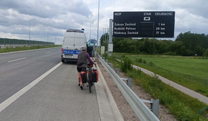 kobieta jedzie rowerem po autostradzie.