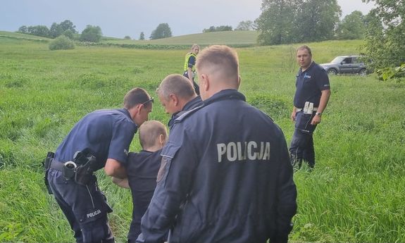 Policjanci prowadzą uratowanego.