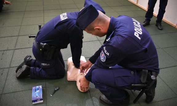 policjant i policjantka udzielają pomocy manekinowi.