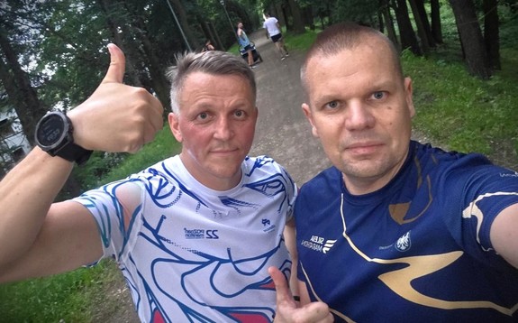 Dwaj sportowcy pozują do zdjęcia.
