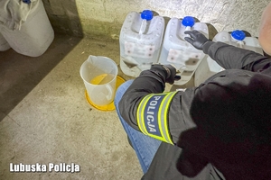 Policjant przy baniakach.