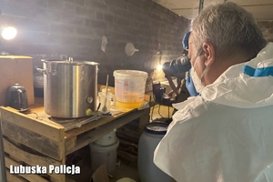 Policyjny technik robi zdjęcie aparatem w laboratorium.