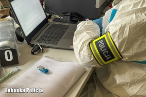 Policyjny technik sprawdza laptopa.