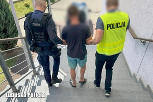 Dwaj policjanci prowadzą zatrzymanego.