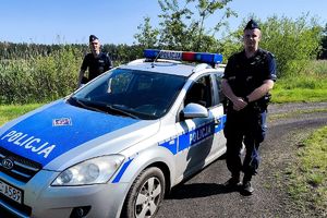 Dwaj policjanci z Posterunku Policji w Skępem przy radiowozie.