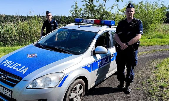 Dwaj policjanci z Posterunku Policji w Skępem przy radiowozie.