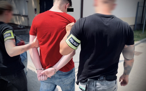 Policjanci prowadzą zatrzymanego.