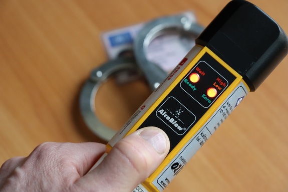 Policjant trzyma w ręku alcoblow.
