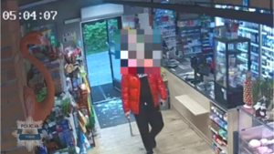 Stopklatka z nagrania monitoringu przedstawia mężczyznę, który z maczetą napadł na sklep.