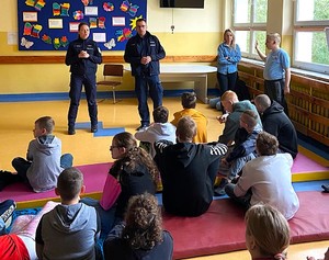 Policjanci podczas spotkania profilaktycznego z grupą dzieci.