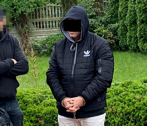 Zatrzymany mężczyzna zakuty w kajdanki.