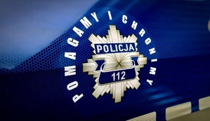 Logo &quot;Pomagamy i chronimy&quot; na drzwiach radiowozu policyjnego.