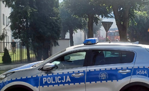 Radiowóz policyjny obok miejsca pożaru.