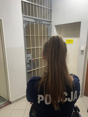 Policjantka przed drzwiami celi.