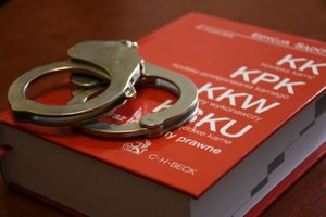 Kajdanki leżące na kodeksie karnym.