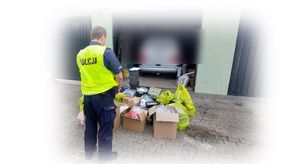 Policjant podczas zabezpieczenia podrobionych artykułów.