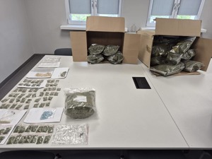 na stole leżą kartony i worki z zabezpieczonymi narkotykami.