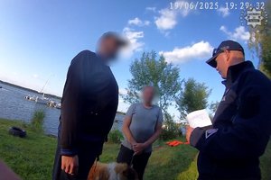 Policjant rozmawia z dwoma osobami.