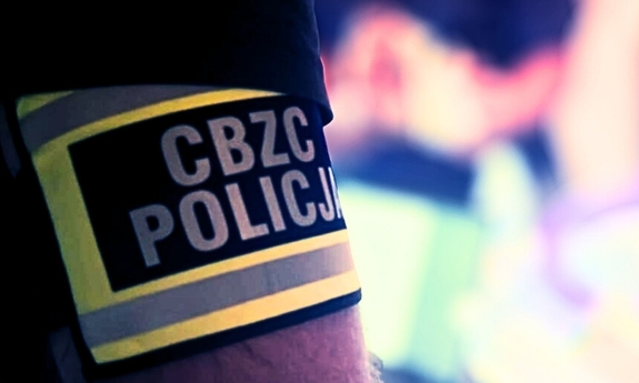 Opaska z napisem CBZC Policja na ramieniu funkcjonariusza.